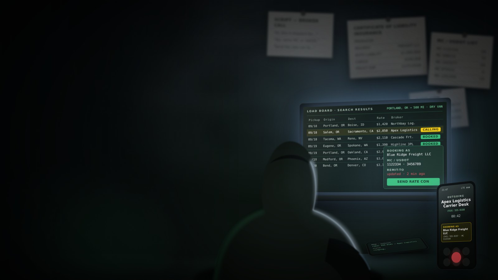 A hooded figure at a laptop in a dark room, calling a broker from a load board while showing a carrier's name that isn't theirs.